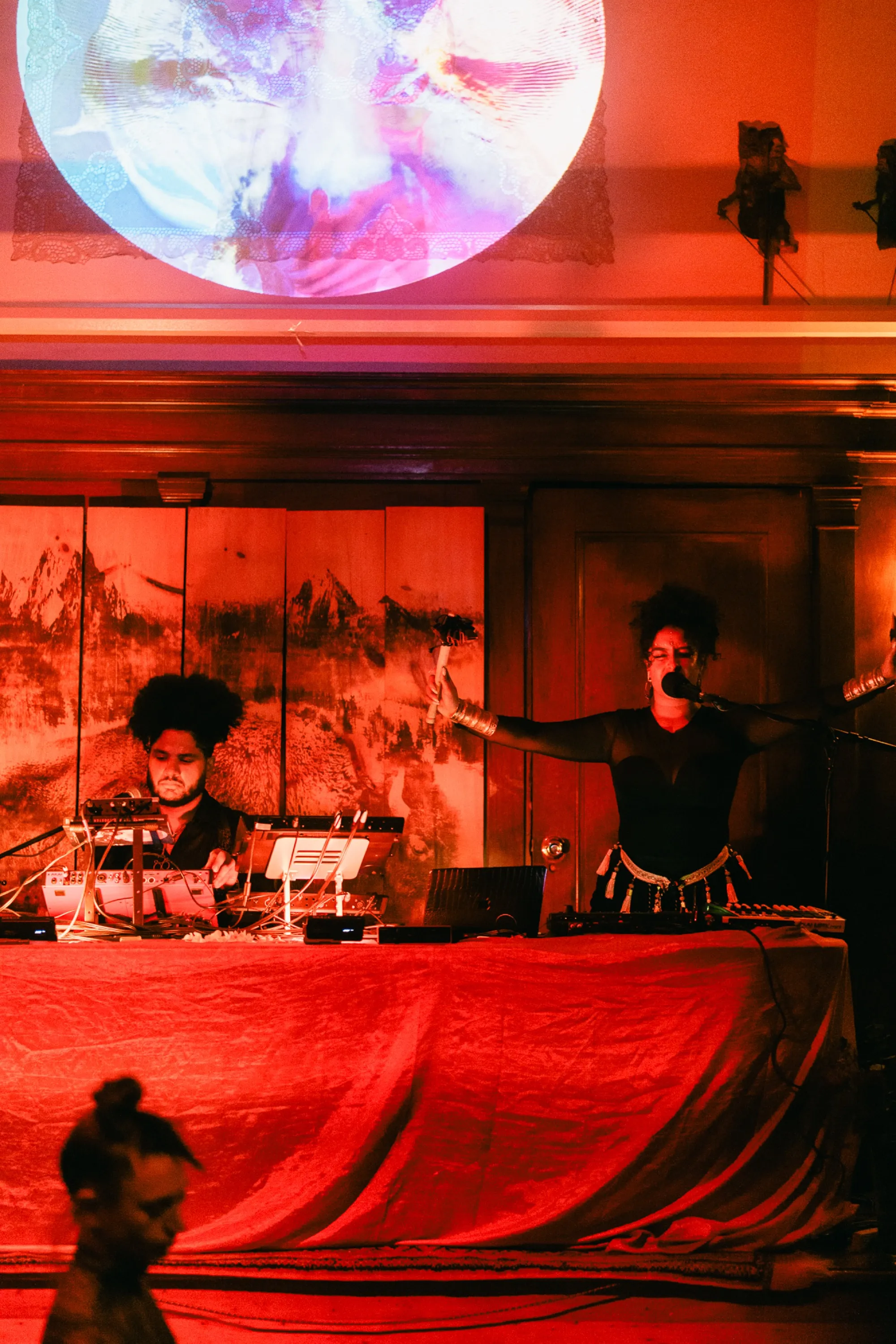 Global artist Benjamin Urbaez and DJ Dreeemy atmospheric shot of live set with warm amber and red lighting
